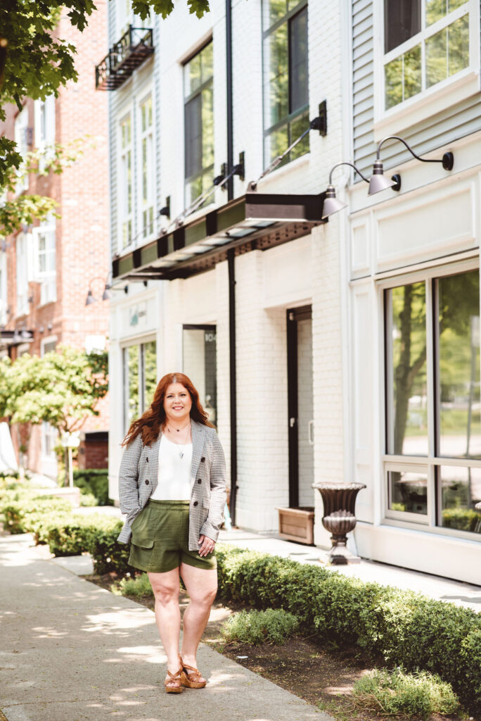 Woman smiling confidently while walking in a sunny city street, supporting others to stop emotional eating.