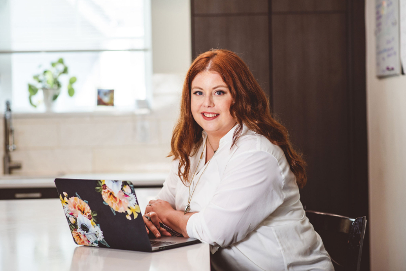 woman working on a laptop at a kitchen table