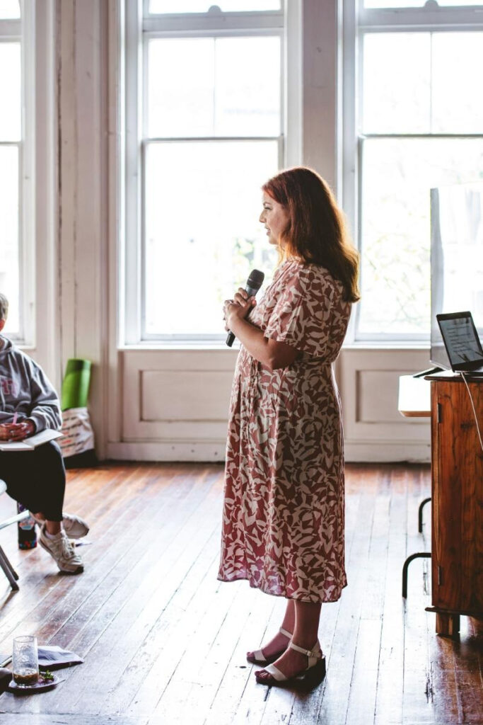 Woman speaking at a workshop about food, self-trust, and asking is it cravings or comfort.