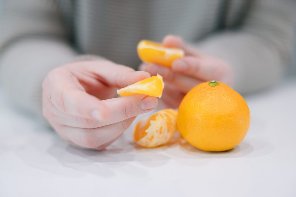 practicing mindful eating holding an orange