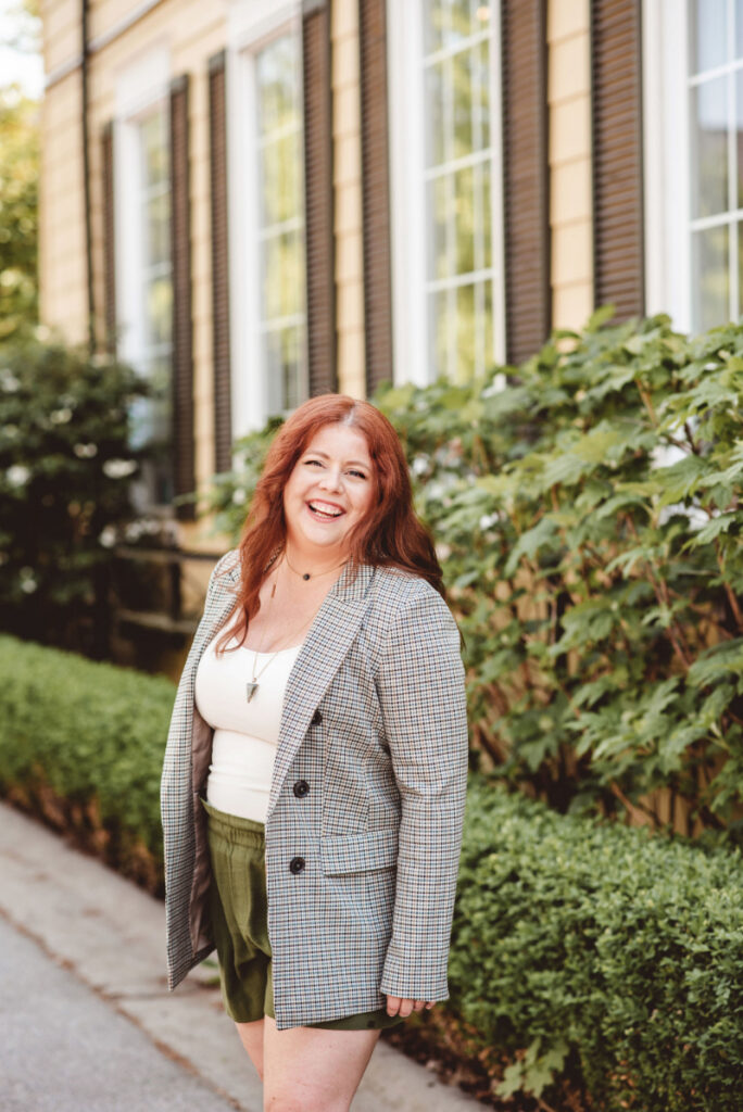 Red-haired woman smiling outdoors, supporting women in finding food freedom and body trust.