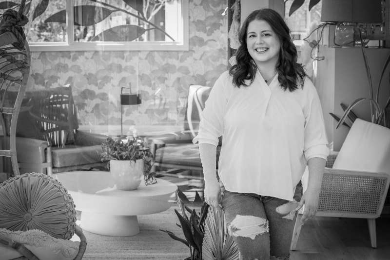 Woman smiling in cozy home setting while discussing healing relationship with food and body image recovery.