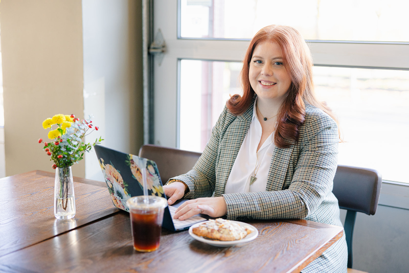Dr. Meredith MacKenzie, binge eating therapist and intuitive eating coach, seated at a laptop sharing support for women struggling with PCOS and binge eating.