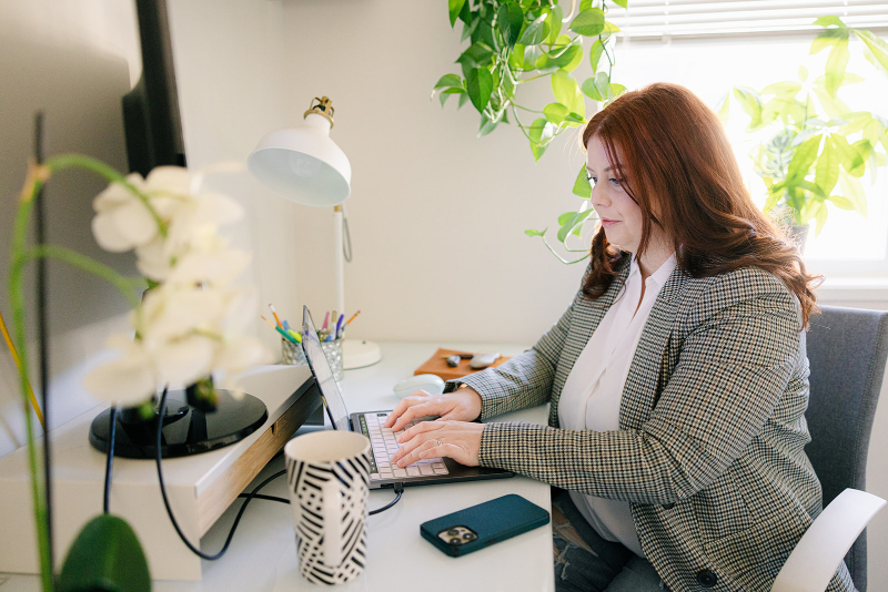Woman working at a desk researching intuitive eating and listening to my body principles.