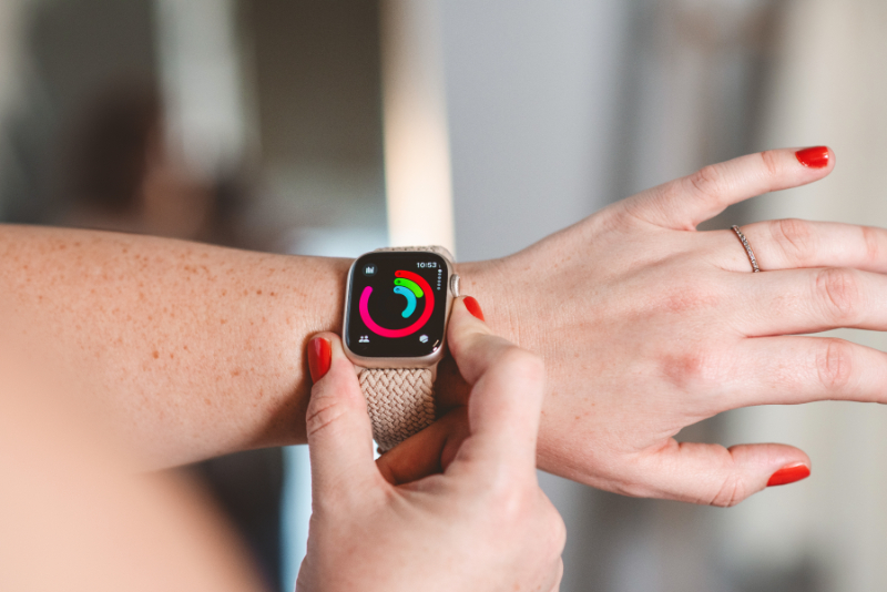 Person checking fitness watch while practicing intuitive movement instead of focusing on calories or exercise guilt.