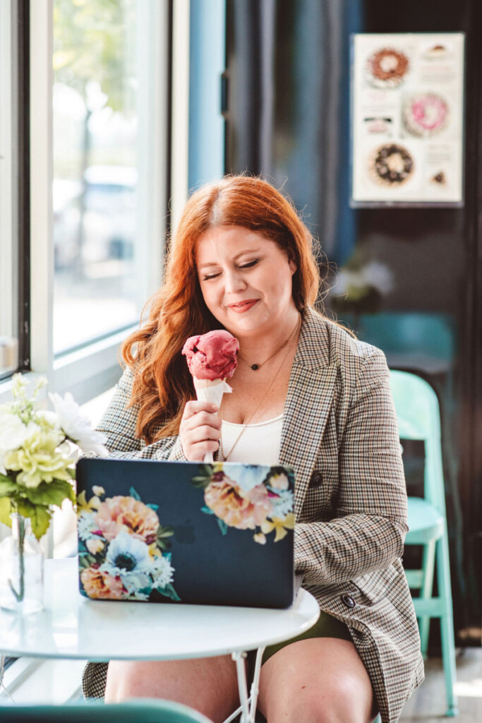 Woman smiling while holding an ice cream cone, showing a compassionate view of stress eating.